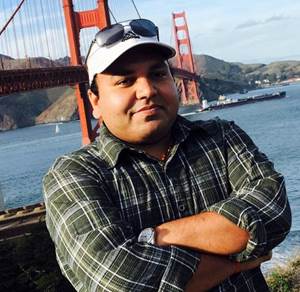 A person standing in front of a bridge

Description automatically generated