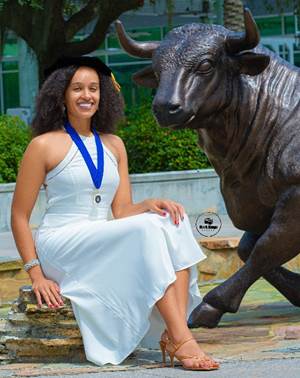 A person sitting on a statue of a bull

Description automatically generated